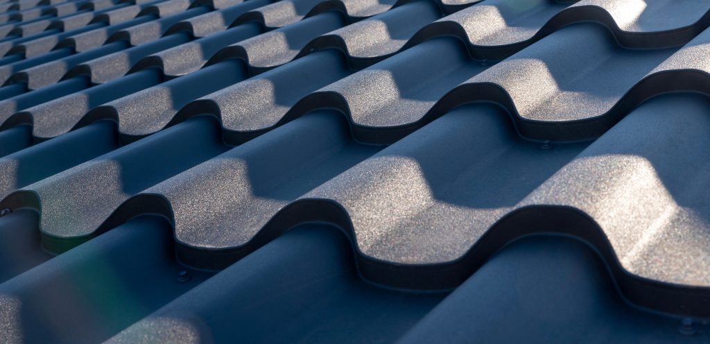 A metal/stainless steel tiling pattern on a modern house roof, exposed to harsh sunlight.