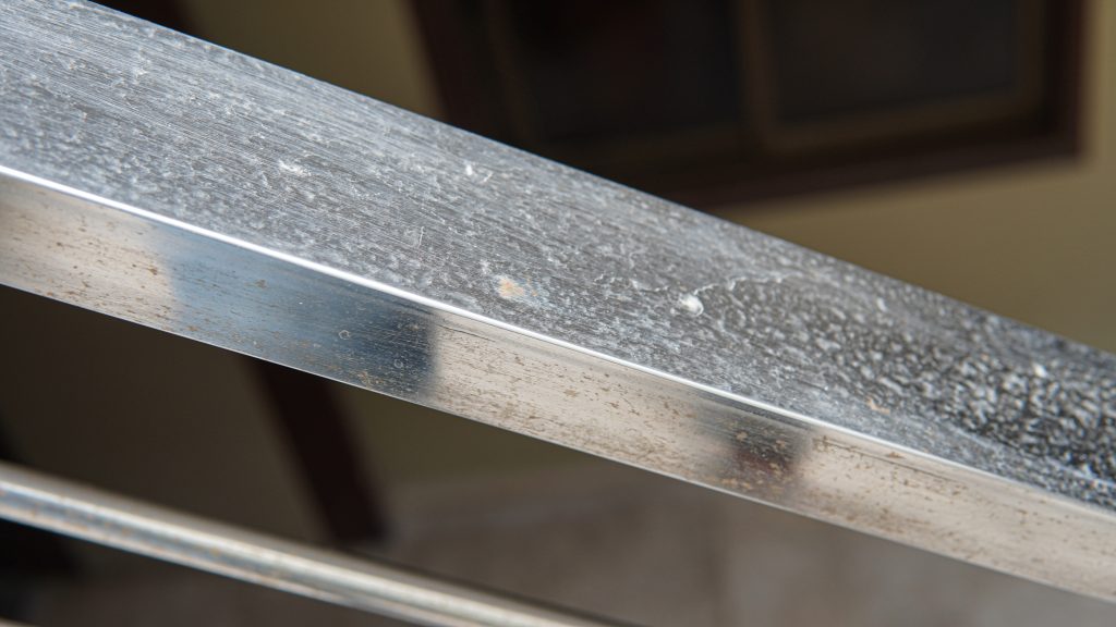 A stainless steel hand railing beginning to rust.