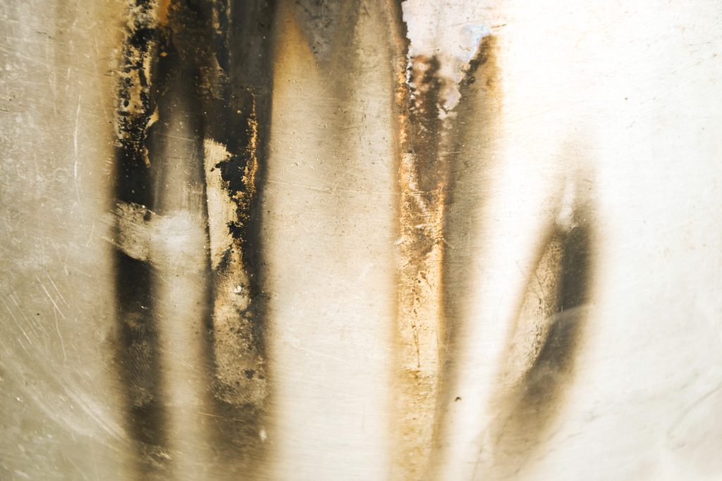 Black, soot-like carbon deposits on a stainless steel surface